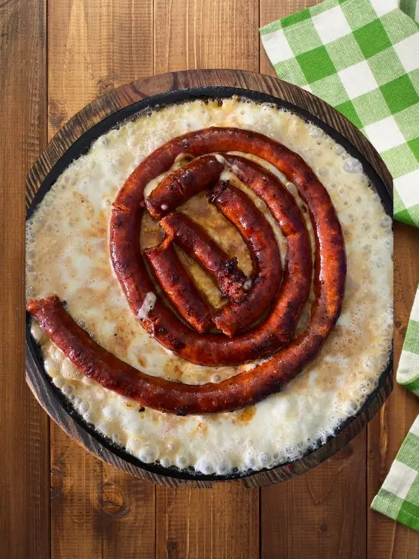 Entrada de chistorra premium asada con queso fundido, servida en el restaurante TBoncito en Tlalpan, CDMX.