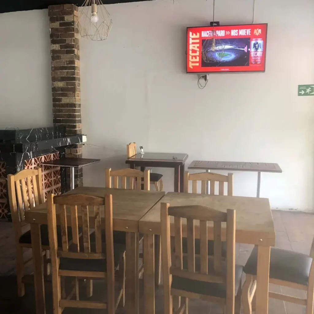Área de mesas en el segundo piso de TBoncito con pantallas para eventos deportivos y parrilladas en Tlalpan.